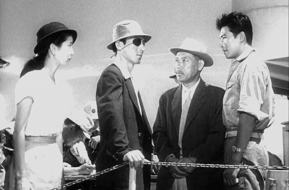 A photo from the original Godzilla film, with people wearing a variety of hats.