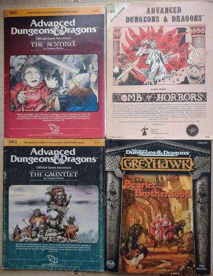 The Sentinel for Advanced Dungeons & Dragons 1st Edition: a very odd-looking woman with black fingernails menaces a character wielding a sword and dagger.

Tomb of Horrors: A very funky-looking lich accompanied by a very large bird and a gargoyle is coming towards you.

The Gauntlet: Some creatures with Asian-inspired armor accompanied by a giant preparing to throw a large boulder.

The Scarlet Brotherhood: two foppish-looking men watch as hideous creatures with whips attack people in a city street.