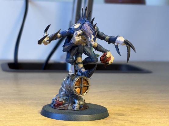 A Genestealer Patriarch miniature, base coated in blue and purple. 