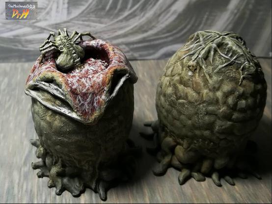 A pair of Alien eggs. One open with a facehugger emerging. high angle from the rear with moody lighting.