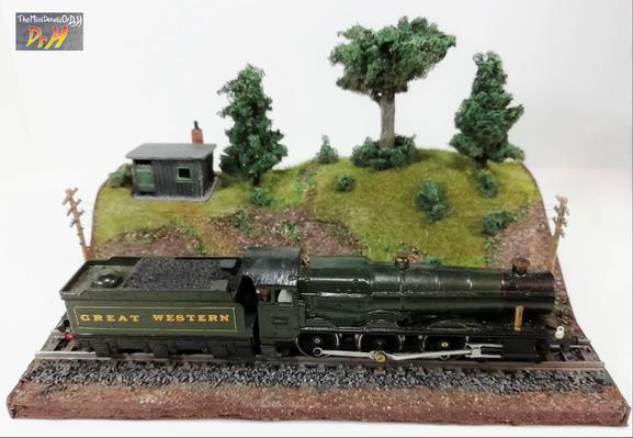 Model train display base, with train. Front view, high angle.