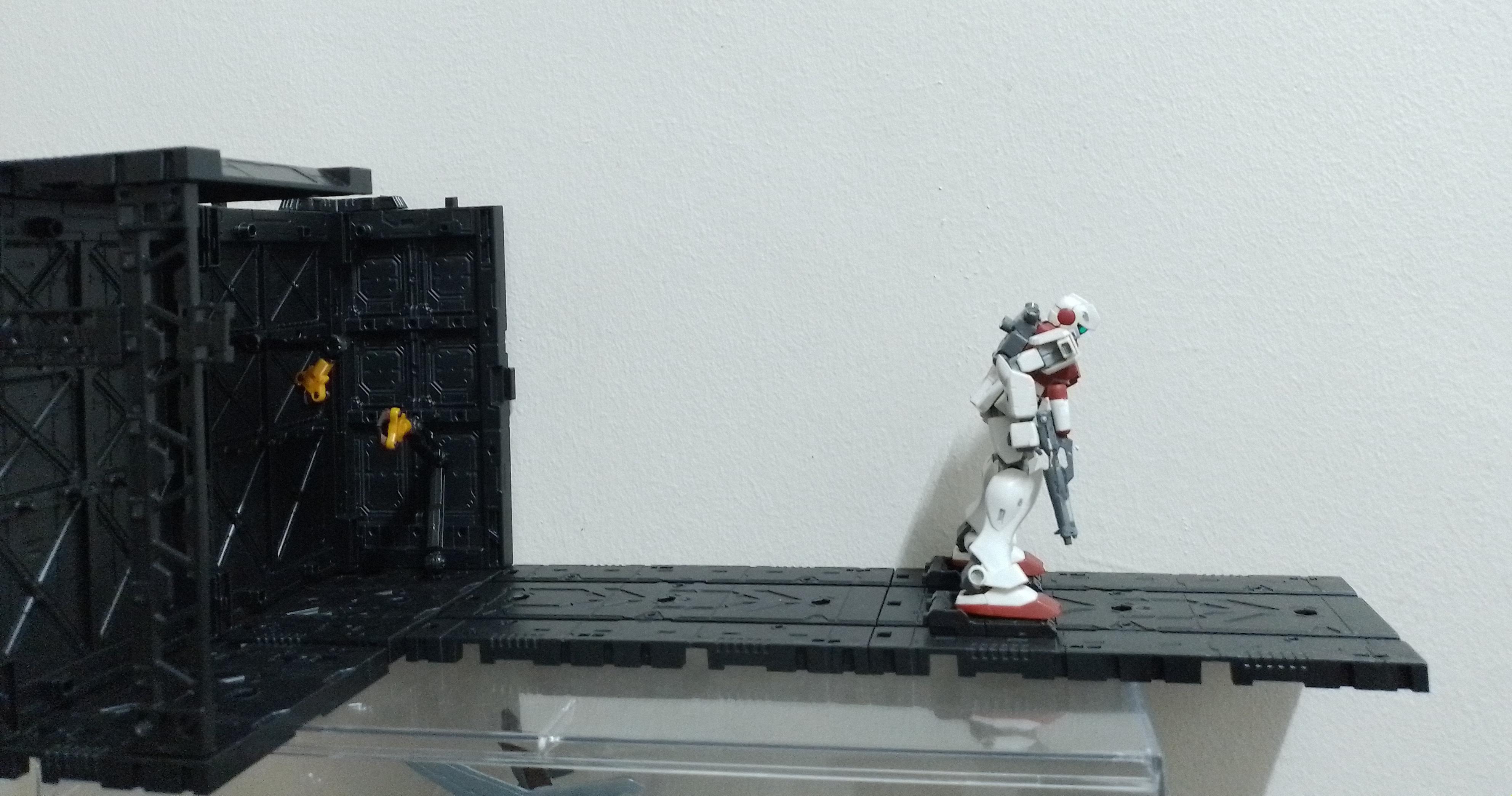 A model of a hangar with an attached launch catapult, a mobile suit is lanching from it.