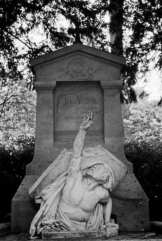 The grave of Jules Verne with the statue off a man breaking out of the grave and reaching to the sky.