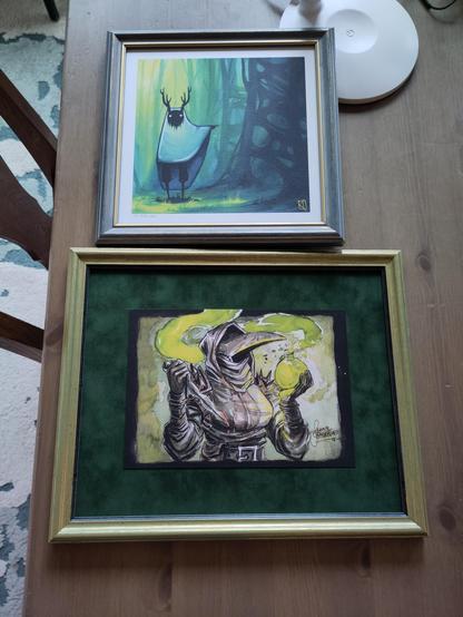 A plague doctor from darkest dungeon in a gold/green frame with green felt as a passepartout which plays nicely with the green in the picture. 