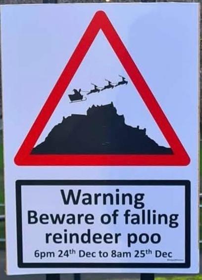 A road sign, showing a silhouette of a flying sleigh pulled by reindeer over what’s clearly a large pile of silhouetted poop, all inside a red caution triangle.

The caption below reads: “Warning—Beware of falling reindeer poo—6pm 24th Dec to 8am 25th Dec”