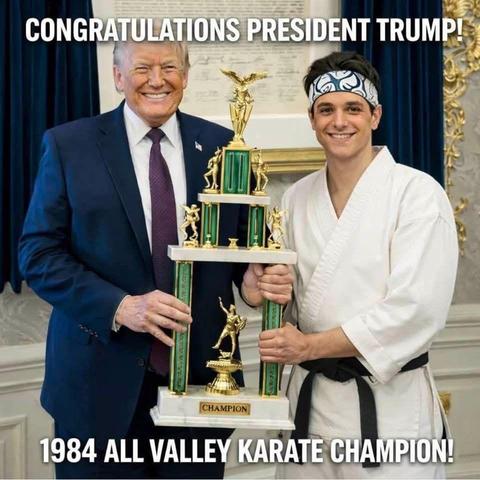 Donald Trump and a young man in a gi (who bears a slight resemblance to a young Ralph Macchio) hold a metre-odd-high, three-tiered, shiny, green and gold karate trophy. Both are smiling, facing the camera.

The top caption reads: “Congratulations President Trump!” And the caption below: “1984 All Valley Karate Champion”.