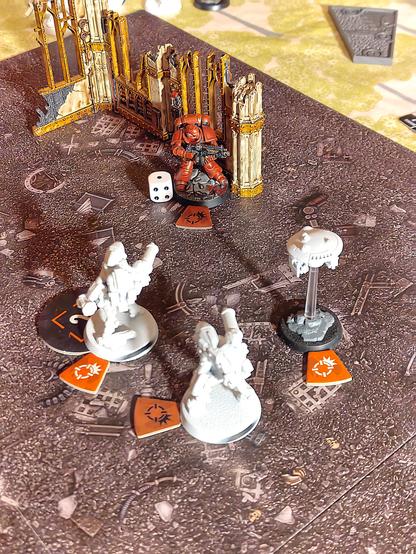 Two stealth battlesuits with burst cannons have a single blood angels operative pinned into a corner.