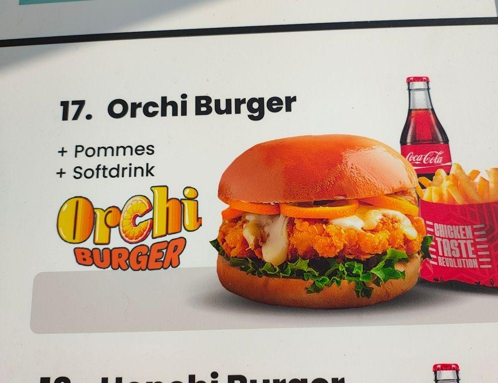 A fast food menu entry showing a strange looking burger, fries, and soda, labelled "orchi burger"