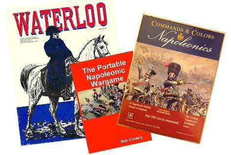 Covers of three Napoleonic-themed wargames overlapping each other: Waterloo, showing a glowering Napoleon on his white horse; The Portable Napoleonic Wargame showing a photo of period miniatures on a gridded surface; and Command and Colors Napoleonics showing a painting of a fierce hussar in the midst of a melee.