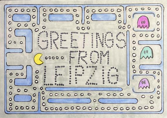 A handmade postcard with a Pac-Man game board and in the center GREETINGS FROM LEIPZIG