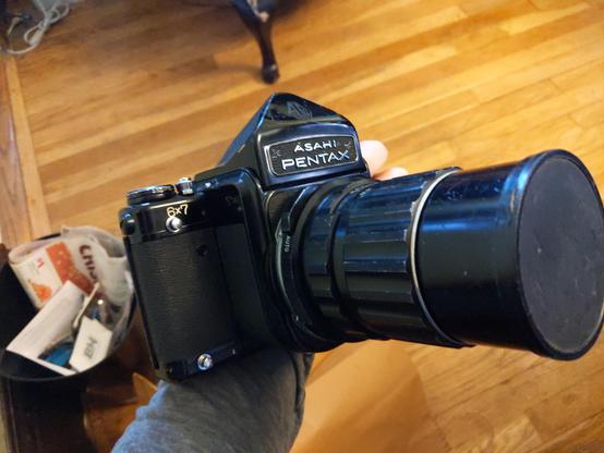 An early Pentax 6x7 medium format camera with a large 200mm lens attached.