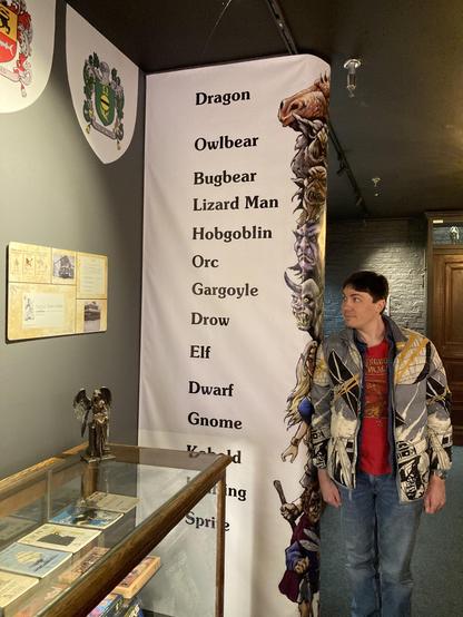me standing next to a tower of D&D creatures labelled by height