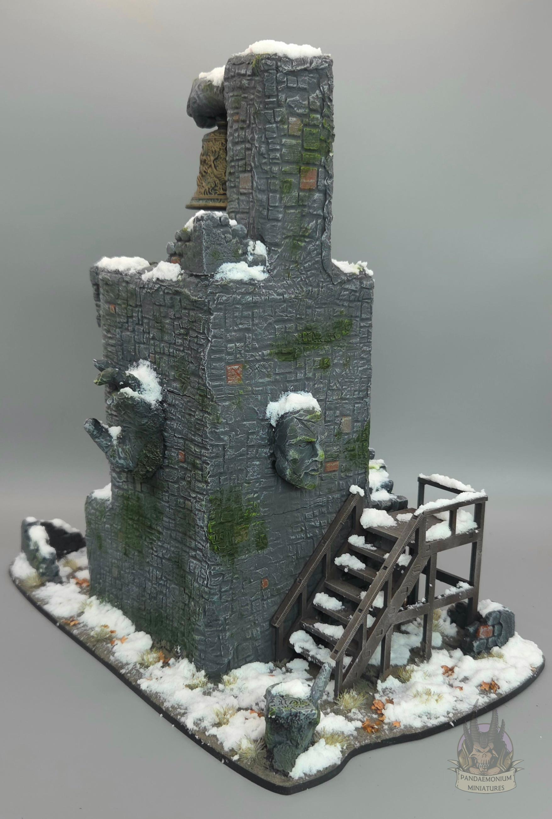 Stone belltower in a snowy setting with carved hand and face projecting from the walls. The first set of stairs is wooden, and the rest are stone, snaking up the outside of the tower. The bell itself is sculpted with a dragon design and clutched in a stone fist. A stone hand points ominously towards the stairs.