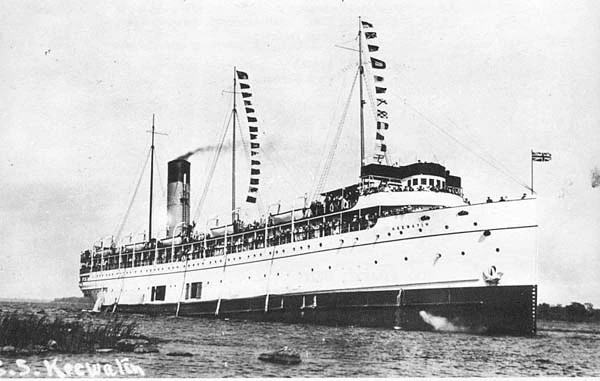 image/jpeg an old black and white photograph of a large white passenger ship with a single aft stack flying flags on its three masts. SS Keewatin