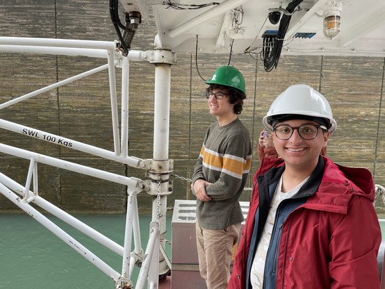 Two students standing on a deck of a ship wearing safety helmets within the walls of a canal.
Photo H Niblock, DFO.