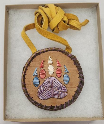 Quillwork medallion by Danilynn Jiibay (2025). Depicts a bear claw (her indigenous clan) containing the trans colors and purple for the quills. Made put of dyed porcupine quills, birchbark, sweetgrass, sinew, and faux leather. This was made during a workshop at her tribal reservation in March.
