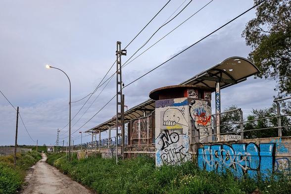 View of the same station from outside. A dirt track leads into the distance parallel to the railway.