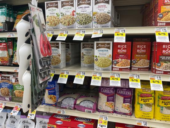 Boxes of couscous surrounded by boxes and bags of rice.