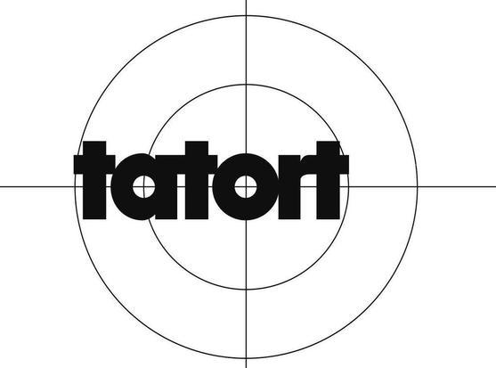 Das Bild zeigt das Logo der Krimireihe "Tatort" in schwarzer Schrift auf einem weißen Hintergrund. Um das Logo herum sind konzentrische Kreise und ein Fadenkreuz angeordnet, was an eine Kamera oder ein Ziel erinnert.