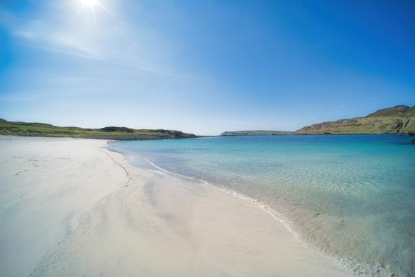 An image of a white sandy beach on a sunny day. Canna, Scotland