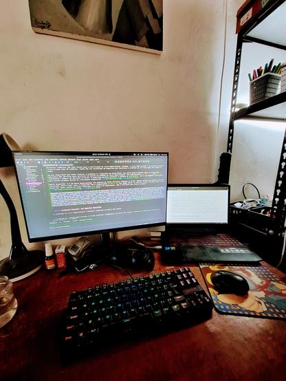 Dual-monitor desk setup with code and research paper on screen, colorful mechanical keyboard, and a focused work atmosphere.