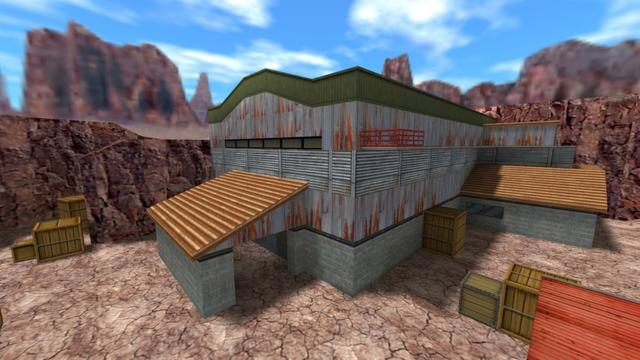 In this picture you can see the main building on the map de_nuke. The entire site is surrounded by mountains. From left to right you can see three light-colored wooden boxes, the entrance/exit to the main building, which is a smaller building, the main building, three more light-colored wooden boxes, a side entrance to the main building, and a red container. The main building and the outbuildings have a concrete brick base, on top of which comes a metal base, which is partially rusted. The annexe have orange pitched roofs. The main building has a catwalk on the side. Narrow windows are embedded in the acade of the main building over the entrance, exit. The roof of the main building is greenish and curved, like a moustache. This is on the map de_nuke in the game Counter-Strike 1.6.