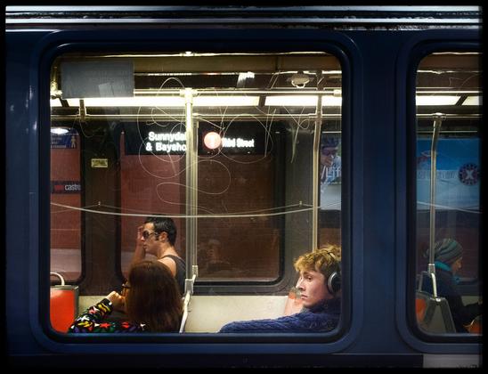 An old shot of a MUNI streetcar in the Castro Street station... Back when the T Third had its old route stretching underneath Market Street.

Inside the streetcar, The main focus is on a redheaded guy wearing headphones and dressed in a cable knit sweater. Also on the train, someone in a tank top and someone else bundled up for colder weather... because it's San Francisco when we have microclimates here.