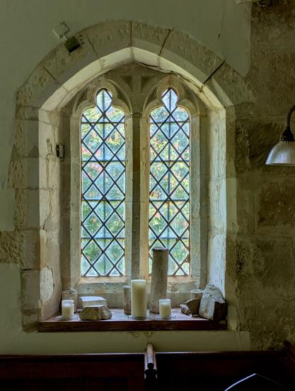 A window in the chancel of St. Mary's church (which dates from C11) in the village of Stoughton, West Sussex, England. May 2025.