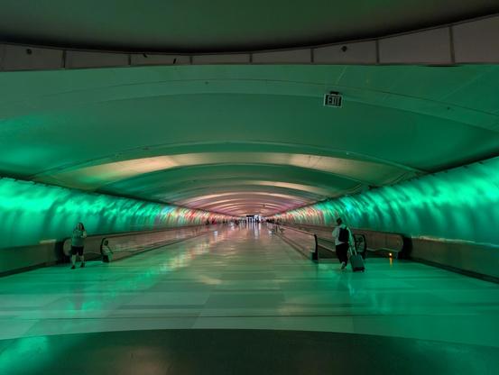 A tunnel with green colored lighting.