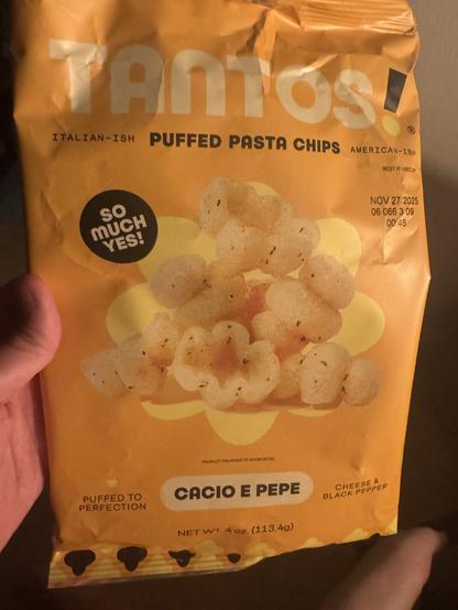 An empty bag of Tantos puffed pasta chips, Cacio e Pepe flavor.
