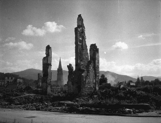 Kriegsschäden in Freiburg im Jahr 1945. Mauerreste ragen aus dem Schutt.