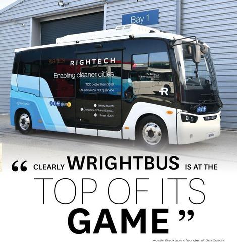 The image shows a modern electric bus parked in front of an industrial building with a sign marked "Bay 1." The bus has a sleek design with a mainly black exterior, accented with blue and white details. Bold branding along the side reads "Rightech," accompanied by the phrase "Enabling cleaner cities." Performance details such as battery capacity, charging time, and range are also displayed. The bus is positioned on a smooth concrete surface, with the building behind featuring metal roller shutters and horizontal cladding.