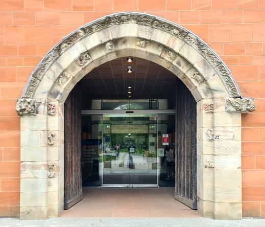 A 14th Century stone arch acting as the entrance to a late 20th Century museum in Glasgow.