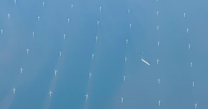 Ein Schiff fährt durch einen Offshore-Windpark in der Nordsee. Die EU-Staaten haben sich angesichts hoher Energiepreise auf europäische Notmaßnahmen verständigt, um Strom zu sparen und Entlastungen zu finanzieren. Die zuständigen Minister einigten sich darauf, dass Energieunternehmen künftig einen Teil ihrer Krisengewinne an den Staat abgeben müssen.