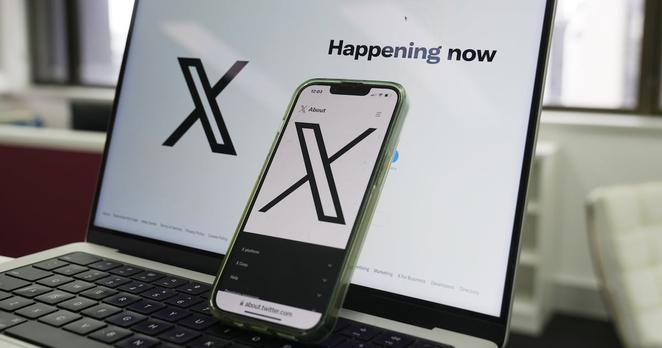 The opening page of X is displayed on a computer and phone, Oct. 16, 2023, in Sydney.