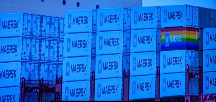 Stacked shipping containers with the logo 'MAERSK' on them, one featuring a rainbow design.