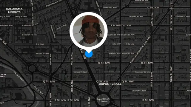 Frame from the 2025 War of the Worlds movie showing a full-frame dark scheme base map of the Dupont Circle area of Washington, D.C., with white labels on a basic dark gray street map. A map marker in a small bright blue circle is overlaid near the center of the map with a popup balloon depicting a photo of a young African American man’s face.