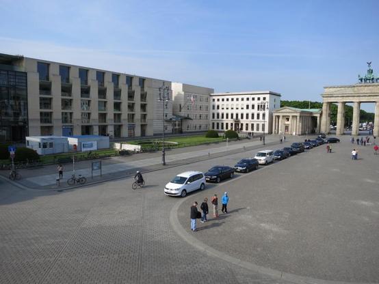 Elevated view of buildings to the south of Berlin’s Pariser Platz, from left to right: the Axica Convention Center (previously the DZ Bank Building), the United States Embassy Chancery, and Haus Somner. The Brandenburg Gate is partially seen on the right side of the photo.