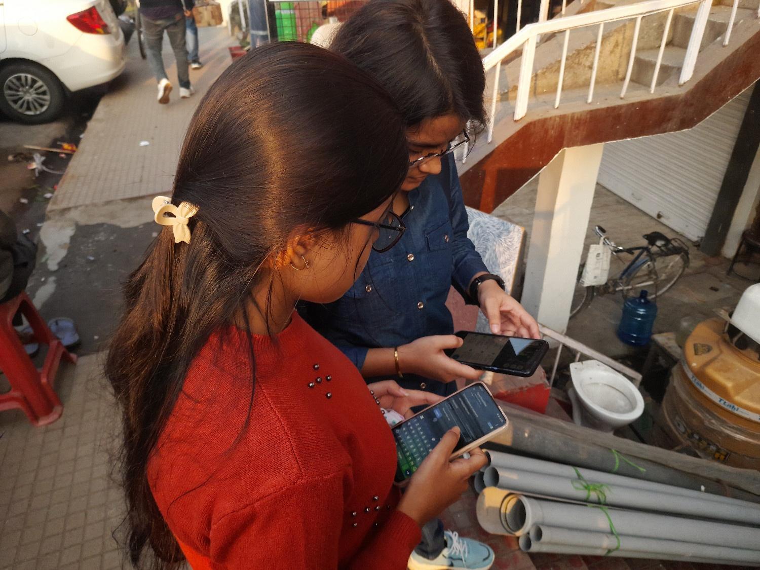 Two women mapping a commercial building, with one of them logging in to their OpenStreetMap account with their editor to get started.