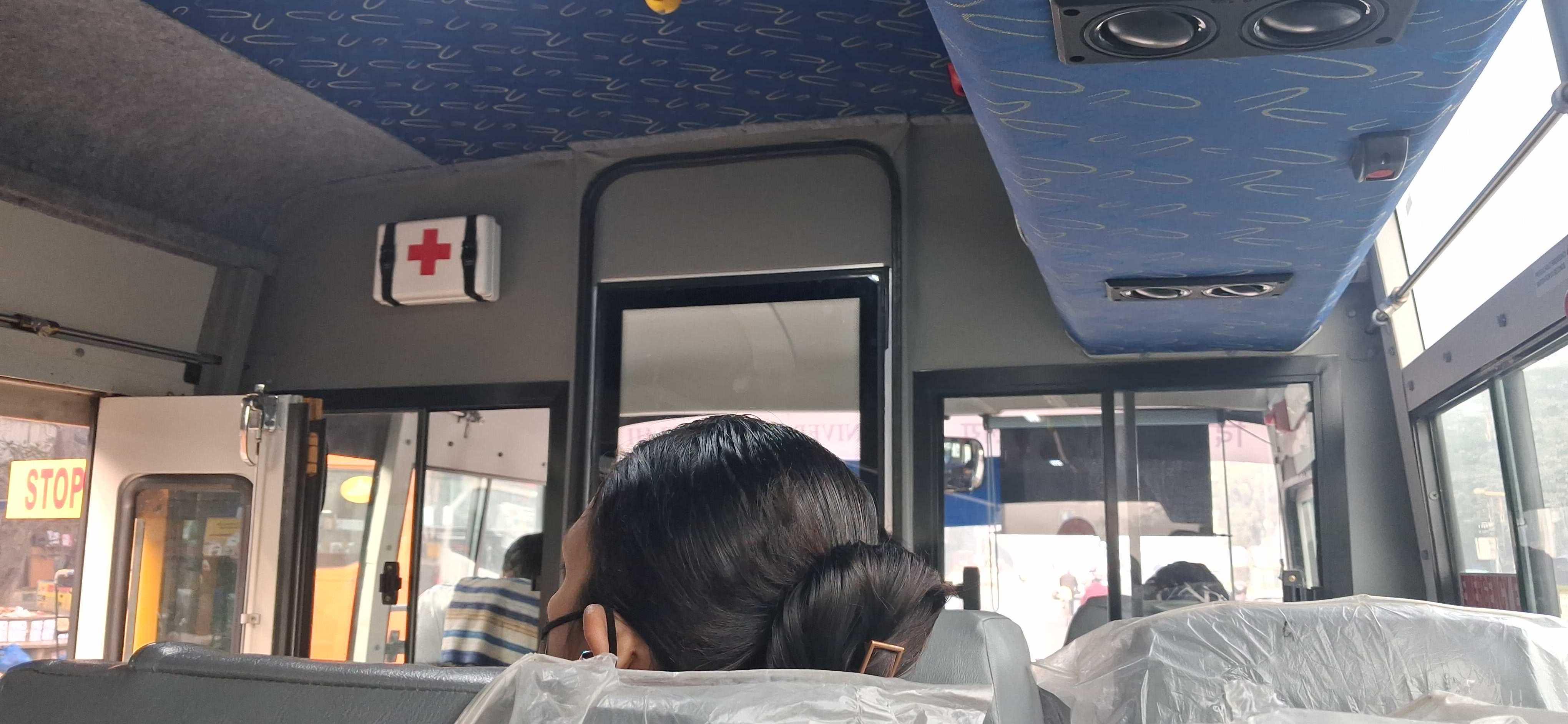Inside of the bus from the front seat. There are AC and First Aid Kit. It is a classic school bus.