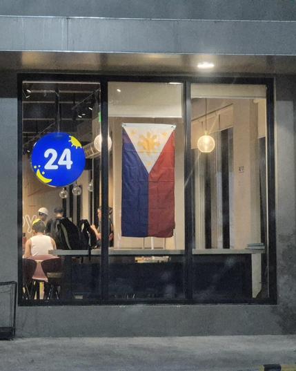 Storefront window with a Philippine flag hanging vertically on the center pane