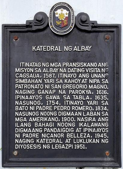 Photo of a cast iron plaque with painted white text on a black base with the following inscription:

Katedral ng Albay

Itinatag ng mga Pransiskano ang misyon sa Albay na dating visita ng Cagsaua, 1587. Itinayo ang unang simbahang yari sa kahoy at nipa sa patronato ni San Gregorio Magno. Naging ganap na parokya, 1616. Ipinaayos gawa sa tabla, 1635. Nasunog, 1754. Itinayo yari sa bato ni Padre Pedro Romero, 1834. Nasunog noong digmaan laban sa mga Amerikano, 1900. Nasira ang ilang bahagi noong I…