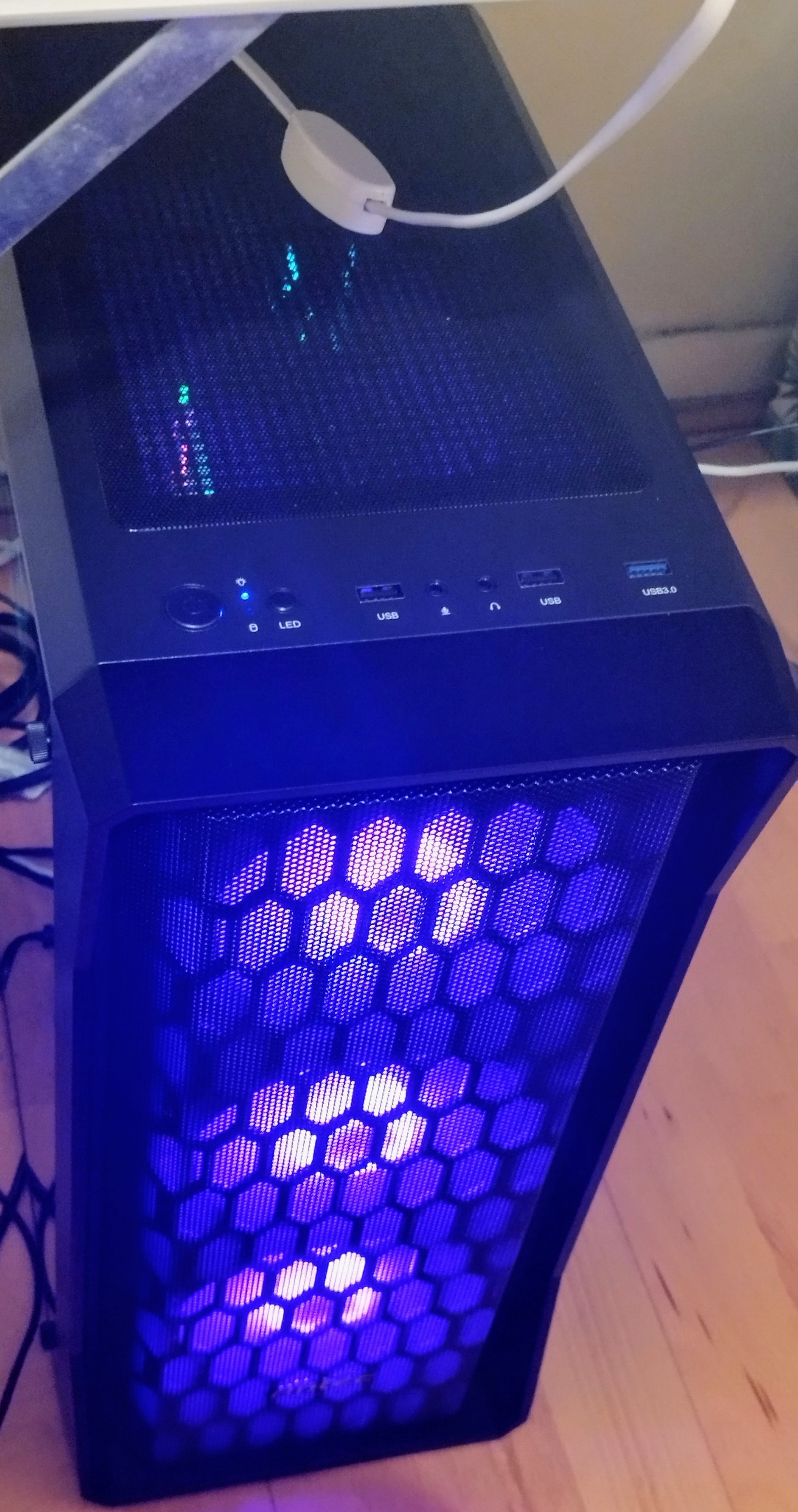 A desktop PC tower with purple light glowing from inside.