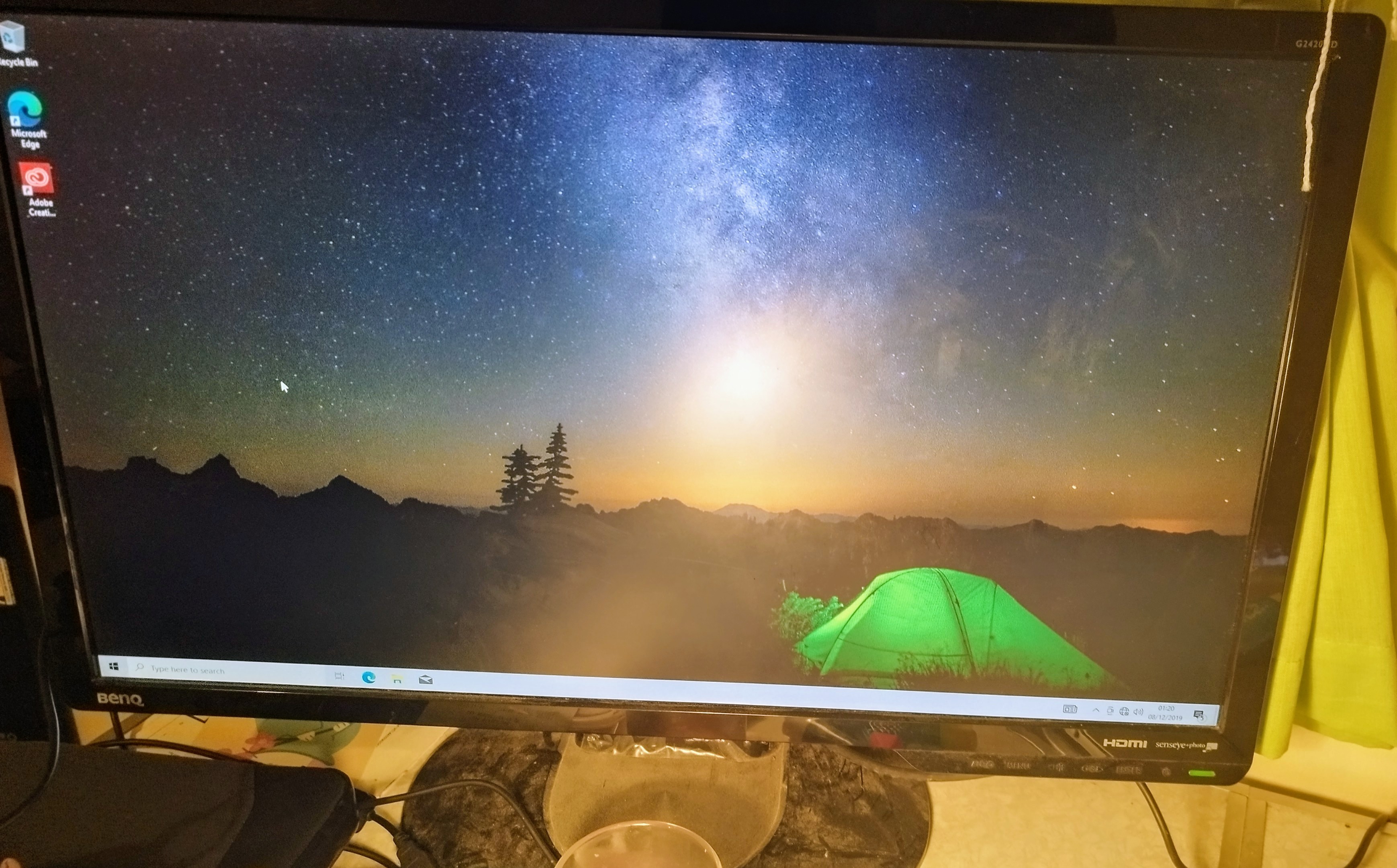 A PC monitor with a stock background featuring a starry sky above a lone green tent.