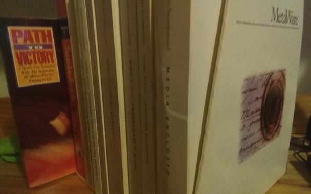 A MetaWare High C/C++ manual set in a box, viewed from a corner of the box, with the included "Path To Victory" New Testament slid out halfway from the box