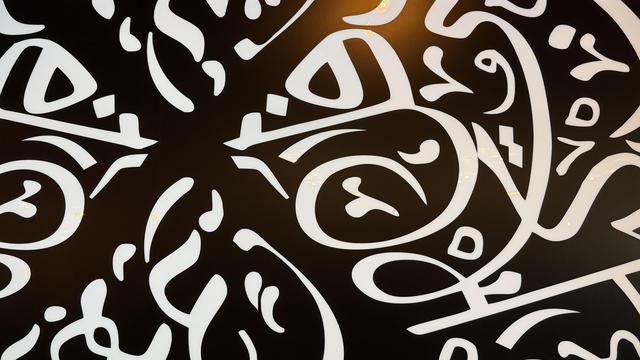 Closeup of window at Dish-N-Dash in Milpitas with Arabic-like writing that is transparent