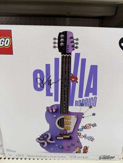 Wide shot of box of LEGO containing the brand new set endorsed by Olivia Rodrigo and lets you build a purple guitar