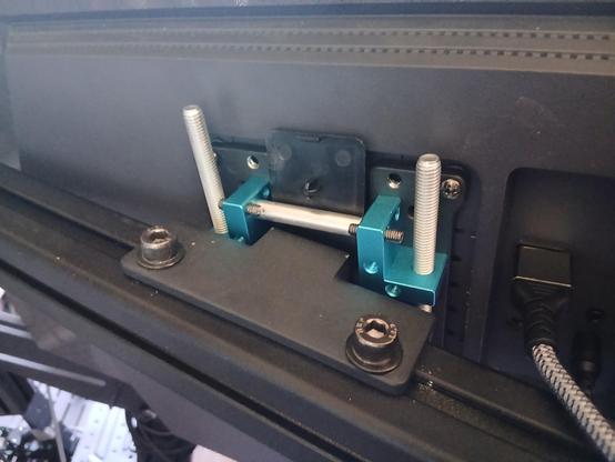 a fancy vesa mounting bracket on an aluminium extrusion with some threaded rods to orient the screen. But there's a plastic plate jammed in there to make it work