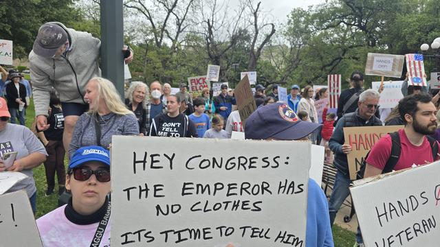 Sign held in the huge crowd: Hey Congress: The Emperor Wears No Clothes, It's Time to Tell Him. 