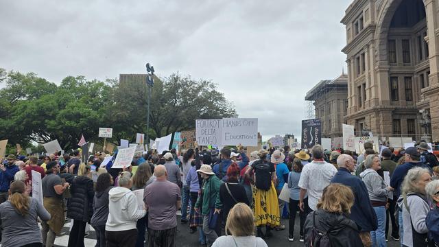 Prominent signs in the crowd include Hands Off Education, Foxtrot Delta Tango, Hey Congress Grow A Spine. 